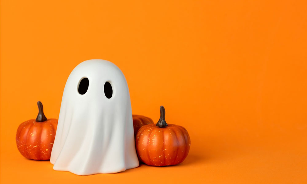 A ghost and pumpins on orange background